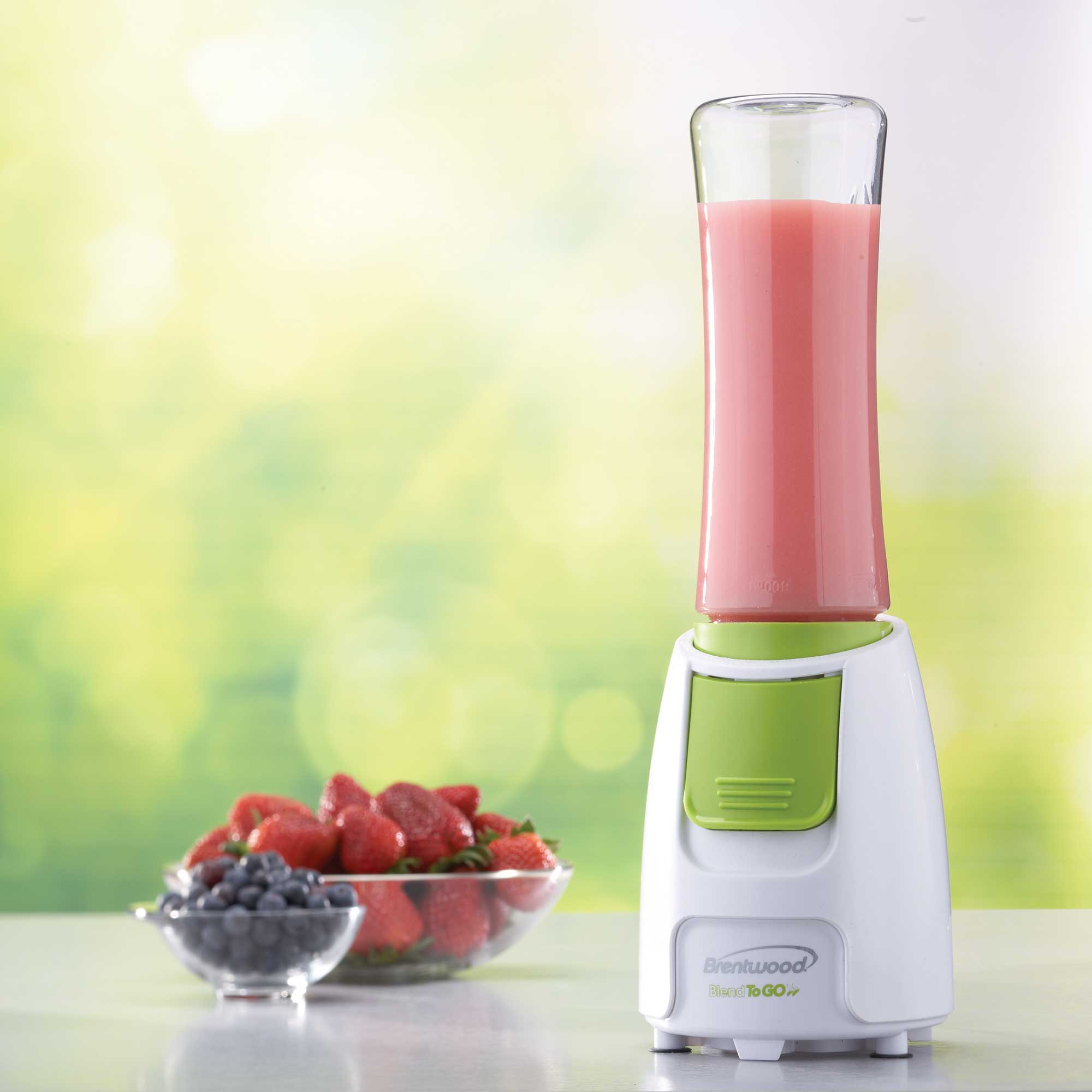 Brentwood personal blender preparing a pink smoothie beside fresh fruit